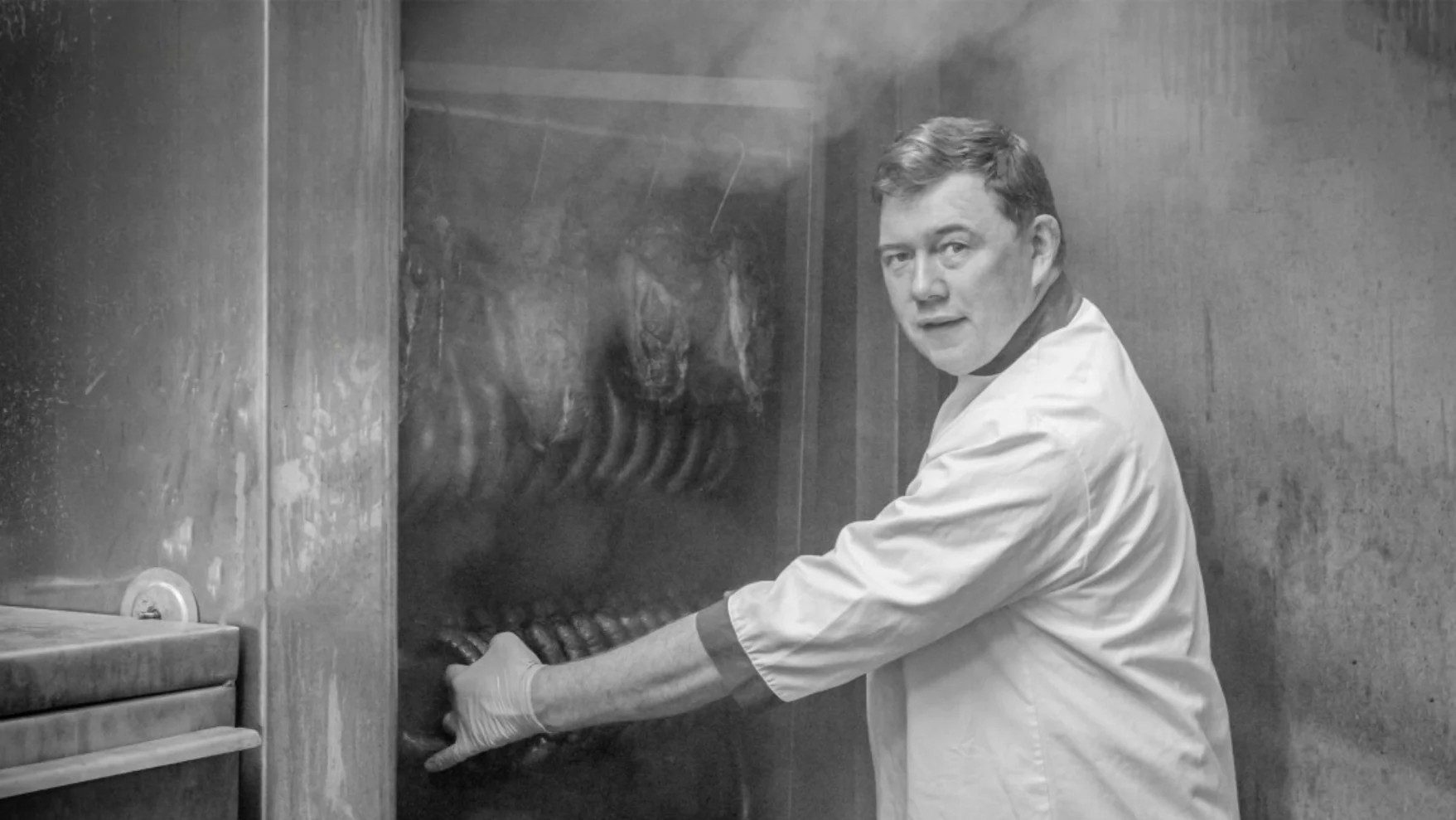 Hugh Maguire hanging sausages in the beechwood smokehouse